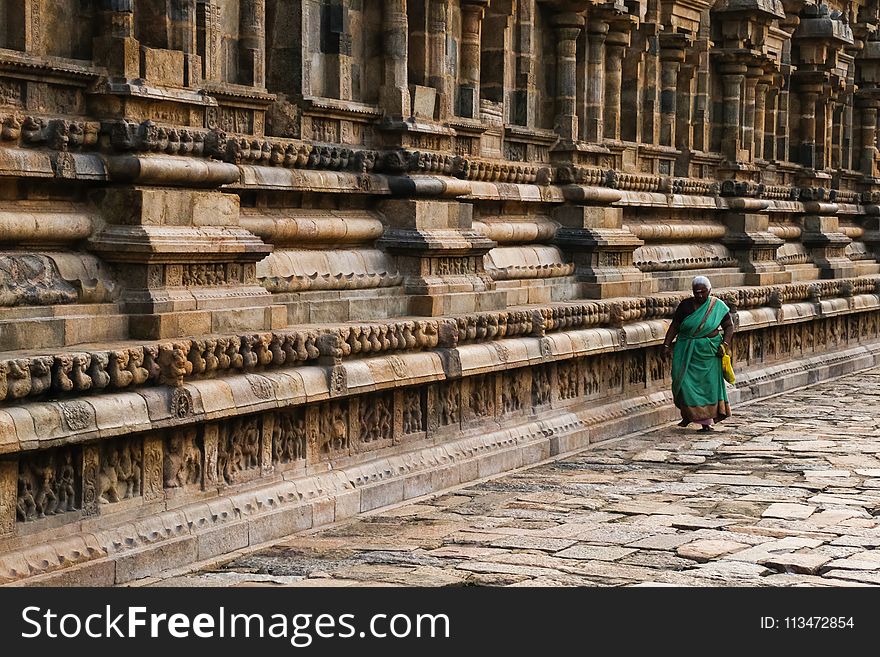 Photo of Woman Wearing Teal Traditional Dress Walking Along Pavement