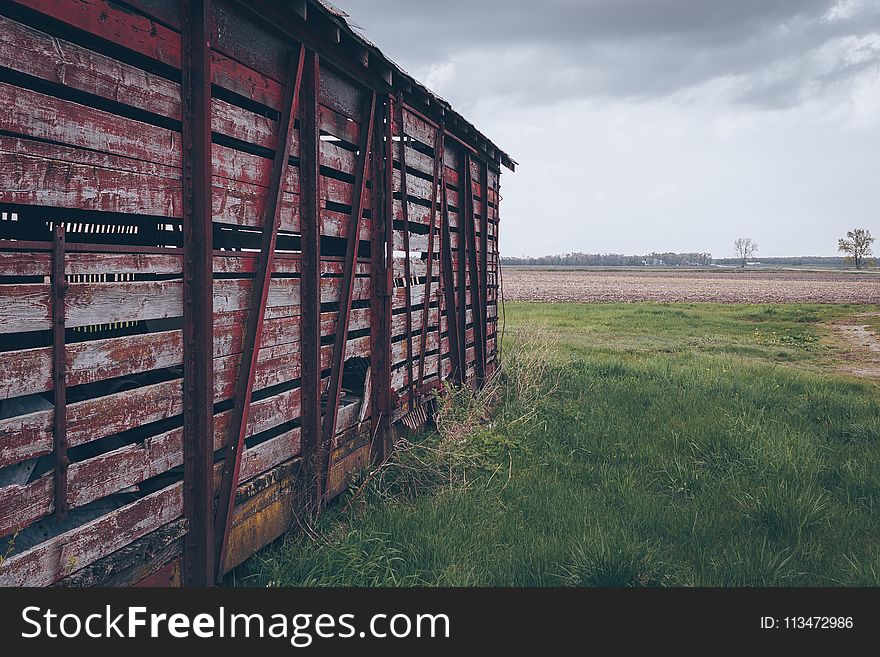 Photo of Red Wooden Shed on Green Grass Field