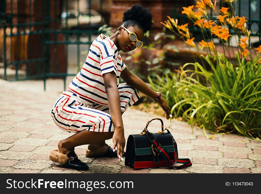 Woman Wearing White Sunglasses and Stripe Shirt Sitting