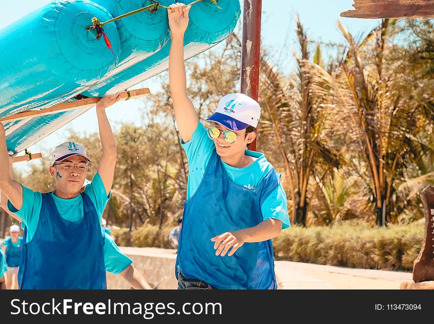 Men In Blue Holding Blue Boat