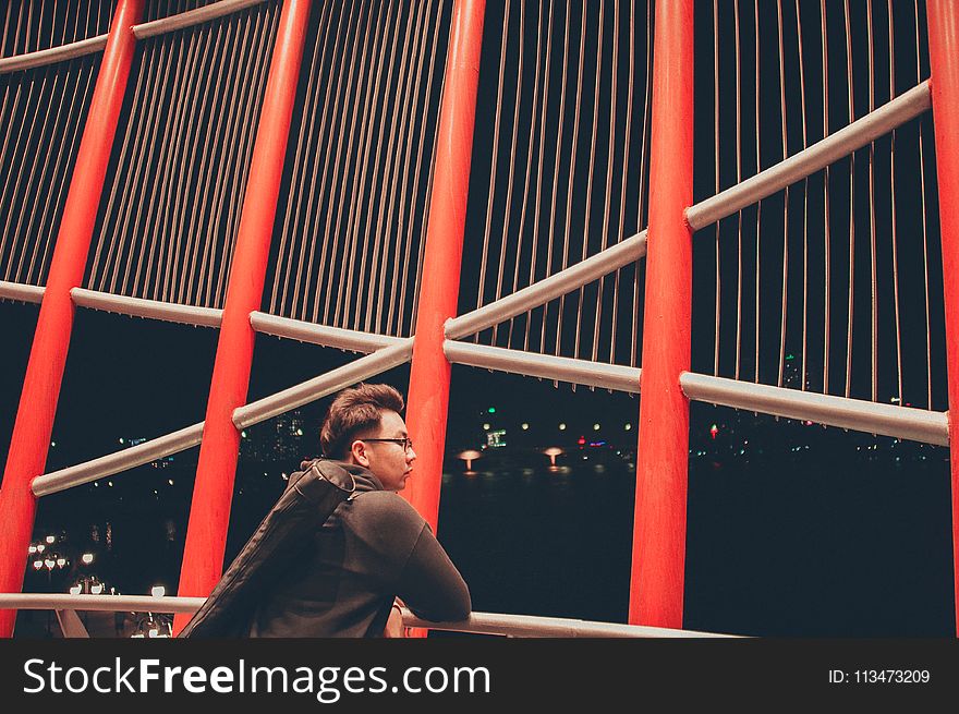 Selective Photography of Man Leaning on White Metal Railings