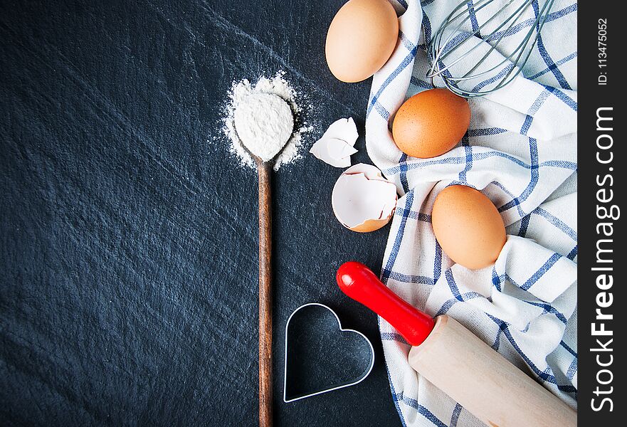 Baking background with eggs and flour on a black stone background. Baking background with eggs and flour on a black stone background