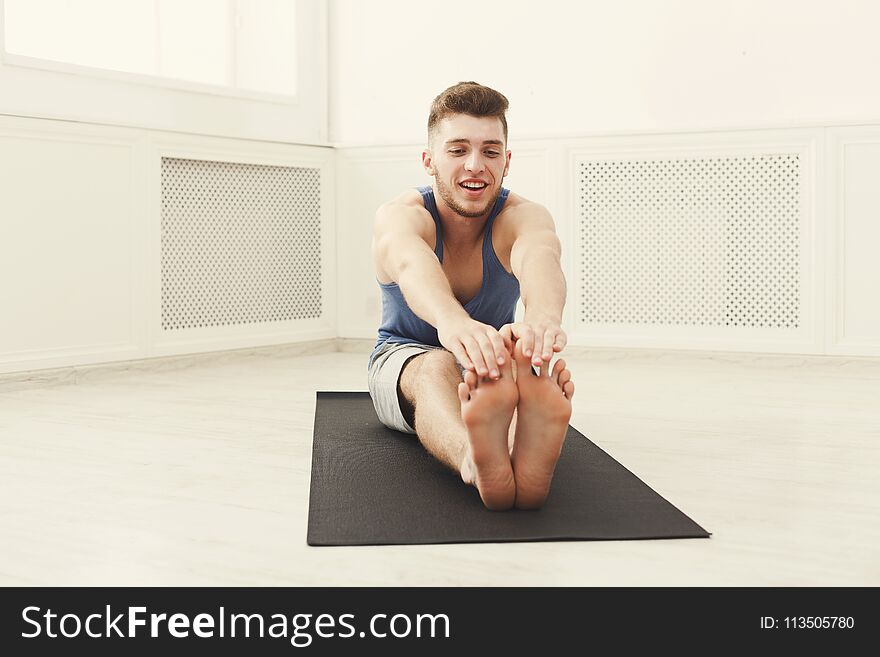 Man stretching at white background indoors