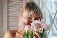 A Blurred View Of A Woman Holding Flowers By The Window, Smiling Stock Image