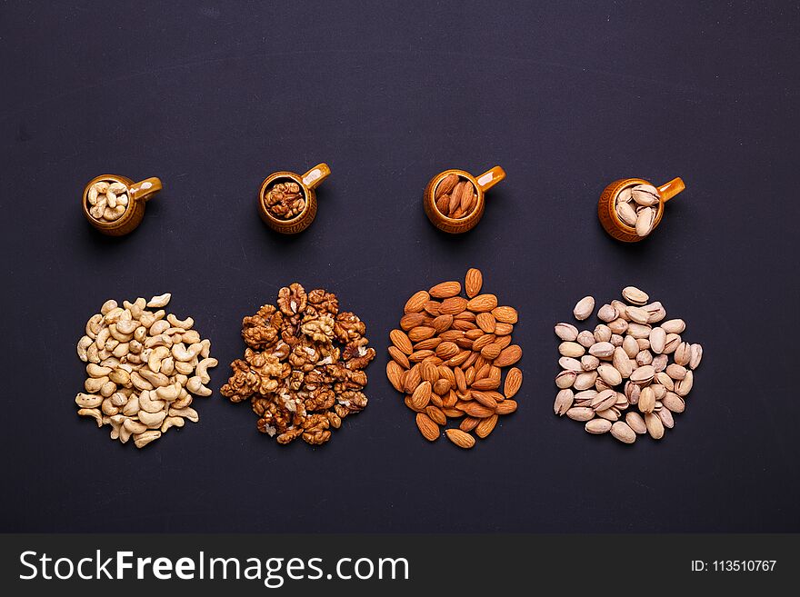 Assortment of nuts on a black background - healthy snack.