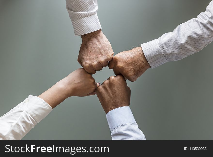 Four Person Hands in White Dress Shirts