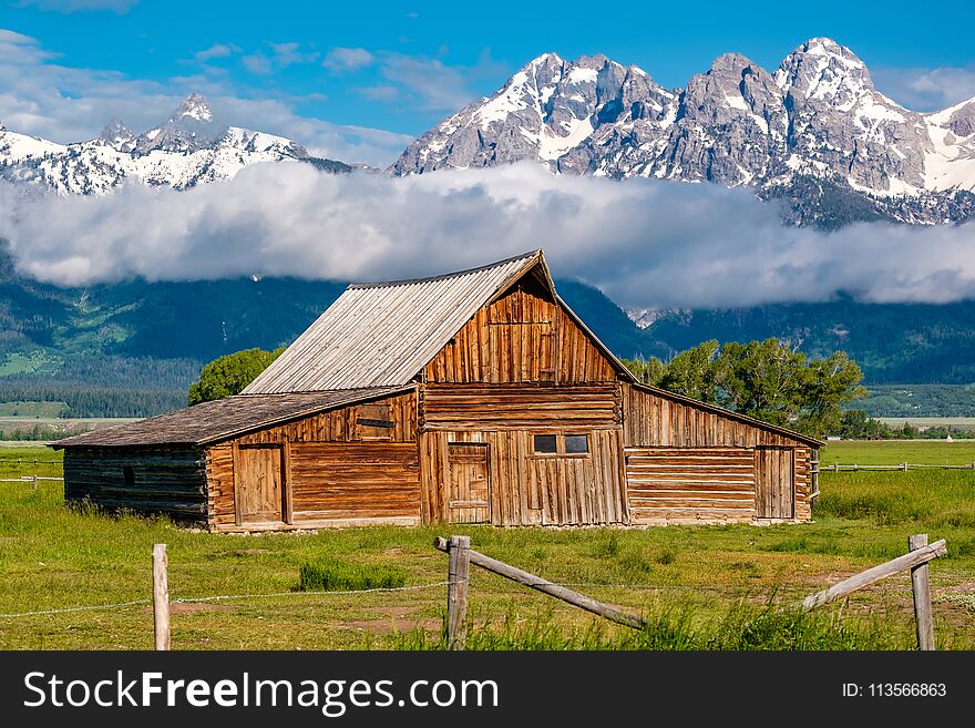 Old mormon barn in Grand Teton Mountains with low clouds. Grand Teton National Park, Wyoming, USA. Old mormon barn in Grand Teton Mountains with low clouds. Grand Teton National Park, Wyoming, USA.