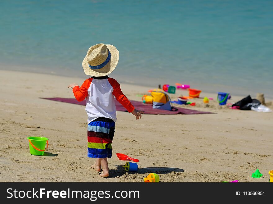 Two year old toddler playing on beach