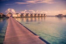 Sunset On Maldives Island, Long Wooden Jetty And Luxury Water Villas Royalty Free Stock Photography