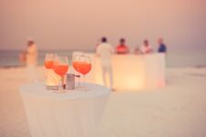 Aperol Cocktail Glasses On Simple White Table. Beach Party Background With Drinks And Blurred People In Background Stock Photos