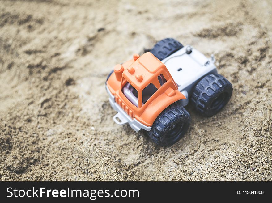 Orange and Gray Plastic Truck Toy on Sand