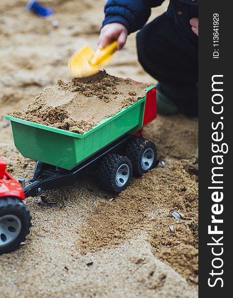 Child Playing Sand With Shovel and Truck Toy