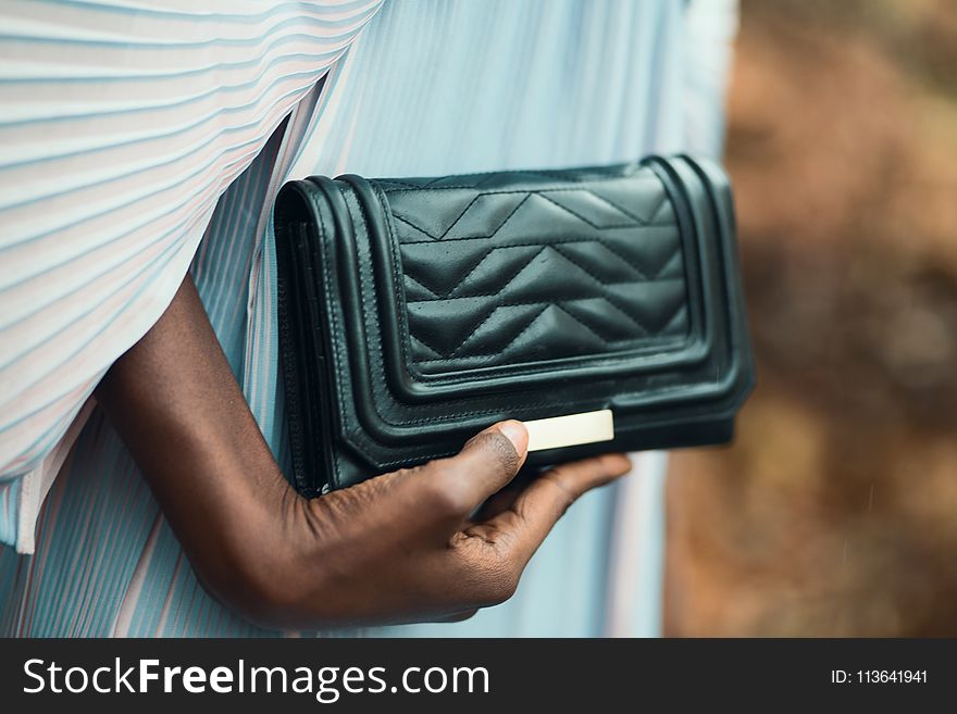 Person Holding Quilted Black Leather Clutch Bag
