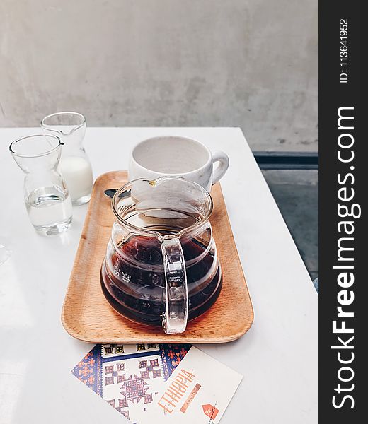 Clear Glass Coffee Pot Near White Mug on Brown Tray