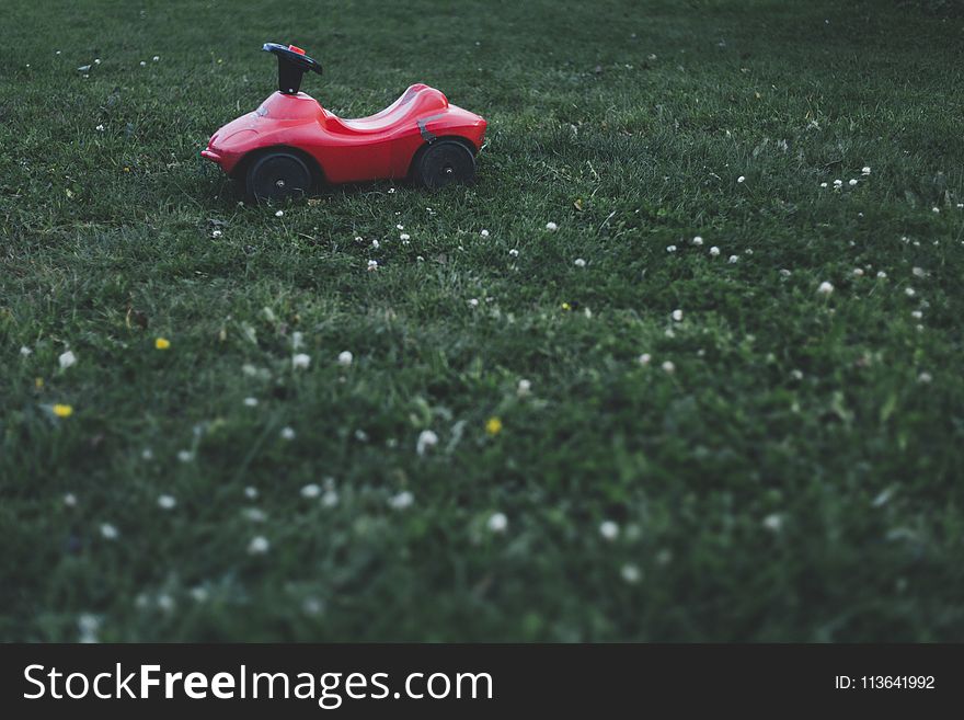 Selective Focus Photography Of Red Ride On Toy