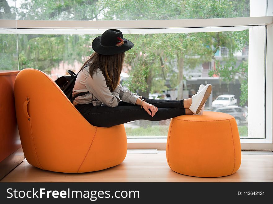 Woman Sitting on Orange Chair