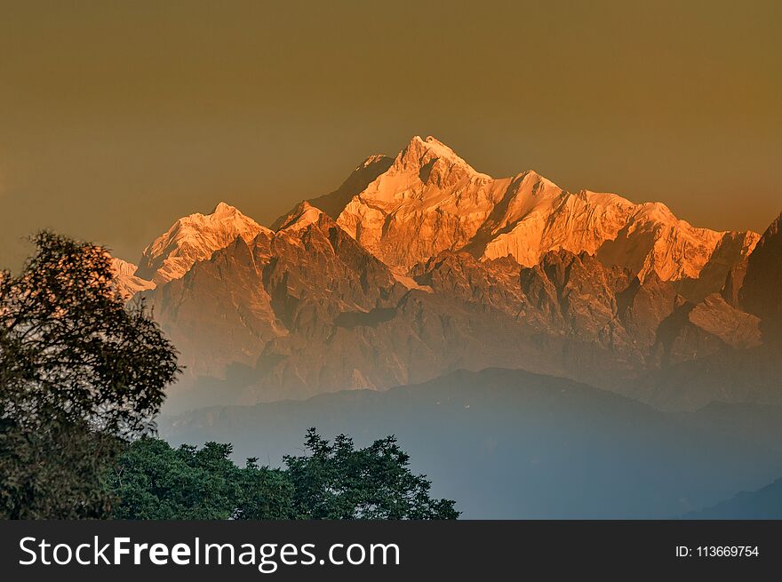 Beautiful first light from sunrise on Mount Kanchenjungha, Himalayan mountain range, Sikkim, India. Orange tint on the mountains at dawn. Beautiful first light from sunrise on Mount Kanchenjungha, Himalayan mountain range, Sikkim, India. Orange tint on the mountains at dawn.