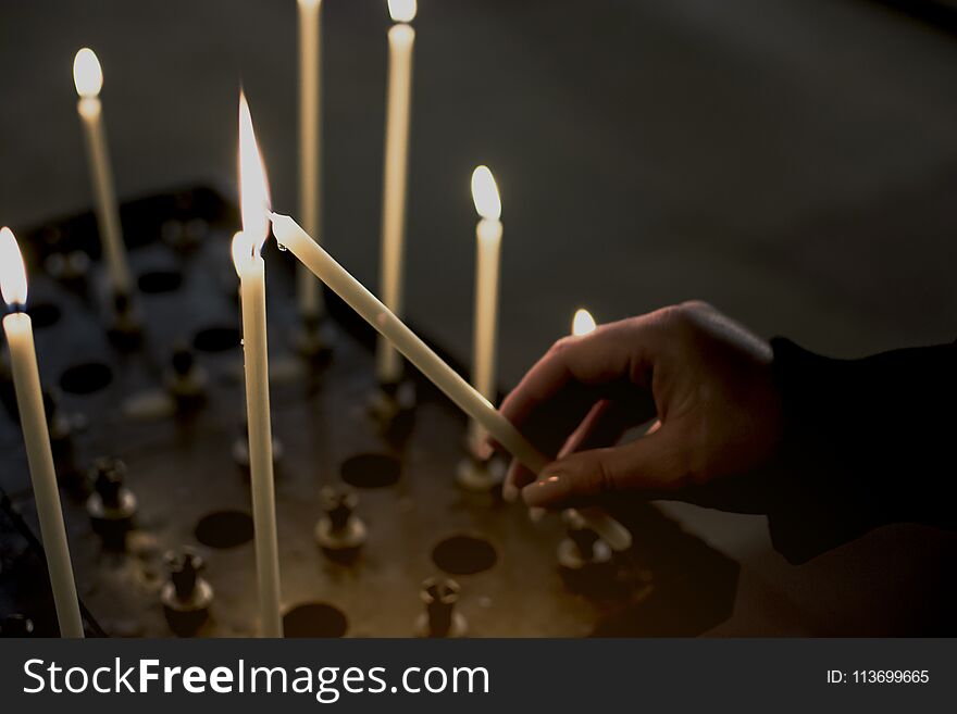 Hand of woman lighting candles in a church