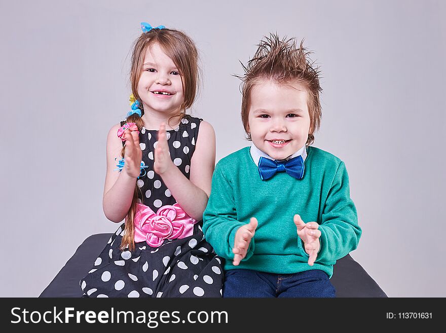 Beautiful little boy and girl clap their hands and smile