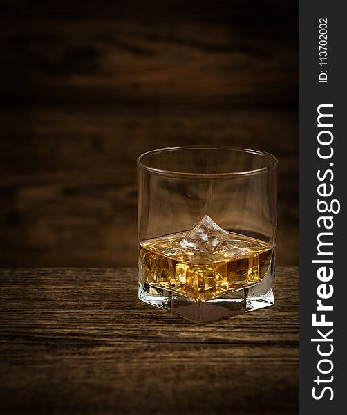 Whisky or whiskey or bourbon with ice on wood background. Whisky or whiskey or bourbon with ice on wood background