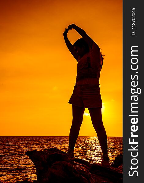 Silhouette Woman Exercise On The Beach Sunset.