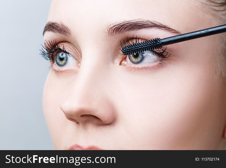 Beautiful woman with long eyelashes in a beauty salon. Eyelash extension procedure. Lashes close-up.