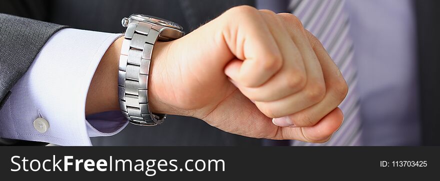 Man in suit and tie check out time at silver wristwatch closeup. Waste minute modern punctual life style start hurry job idea last second clockwork precision concept