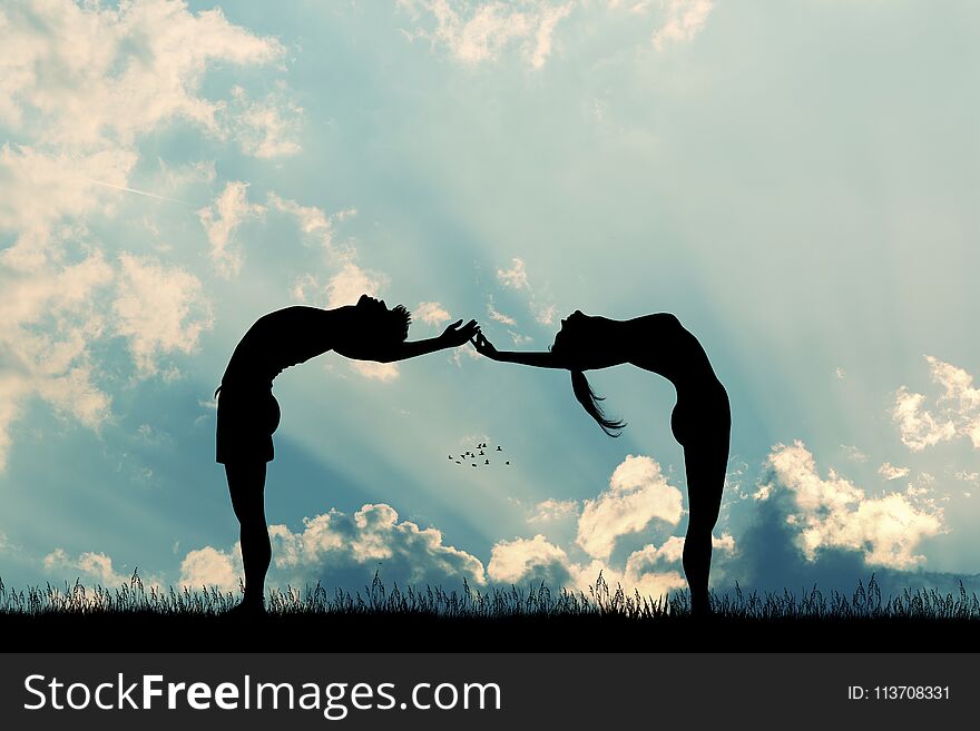Couple makes yoga poses at sunset