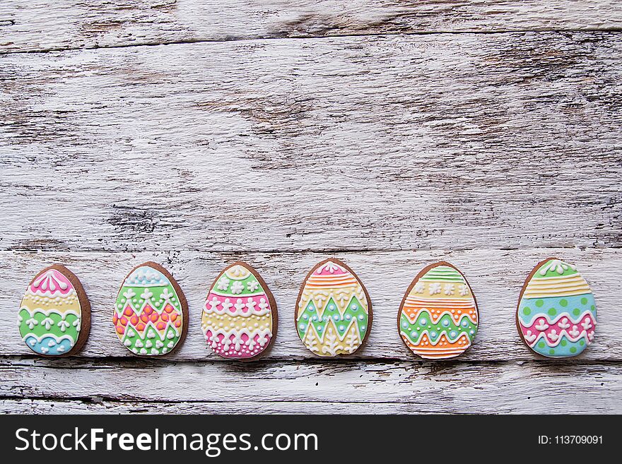 Gingerbread Cookie In The Form Of Color Eggs On Dark Wooden Background.