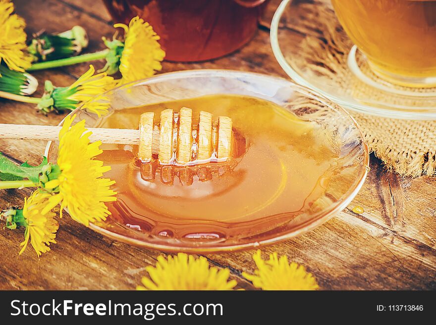 Honey from dandelion and a Cup of tea. Selective focus.