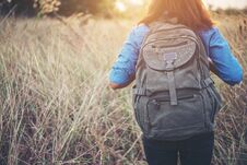Vintage Tone Images Of Beautiful Young Hipster Woman With Backpack Walking On Meadow. Portrait Of Hiker Girl Outdoor. Stock Photography