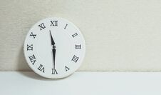 Closeup White Clock For Decorate Show Half Past Eleven Or 11:30 A.m. On White Wood Desk And Cream Wallpaper Textured Background Wi Royalty Free Stock Photos