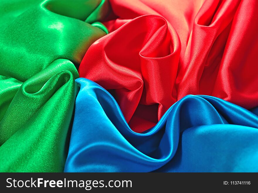 Natural blue, red and green satin fabric as background texture. Natural blue, red and green satin fabric as background texture