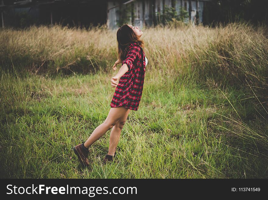 Young beautiful woman enjoying nature in field. Woman raising her arm up in the air enjoy with mature. Women lifestyle with vintage filter.