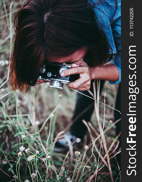 Happy young hipster woman with vintage camera in field. Enjoy with nature sunset, Vintage hipster woman photographer.