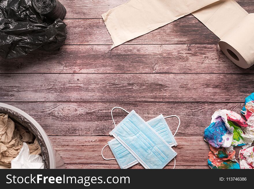 Garbage of dirty paper and sanitary hygiene mask on wooden background composition healthcare concept