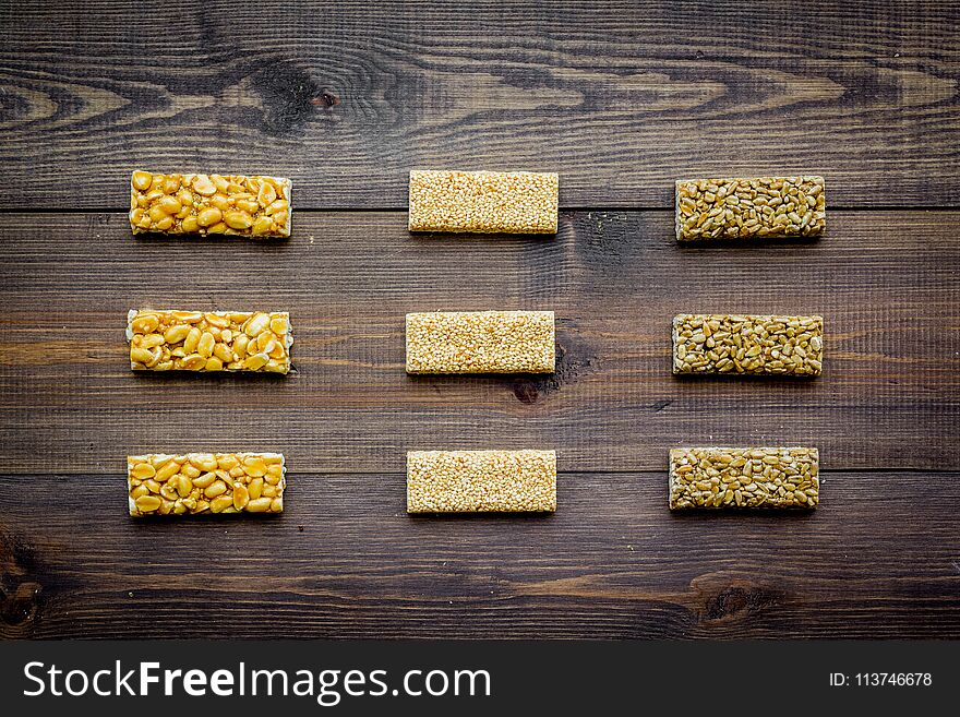 Granola bars for healthy nutritious breakfast on dark wooden background top view pattern
