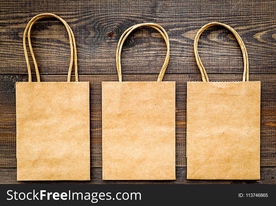 Brown kraft paper bag for shopping on wooden background top view mockup