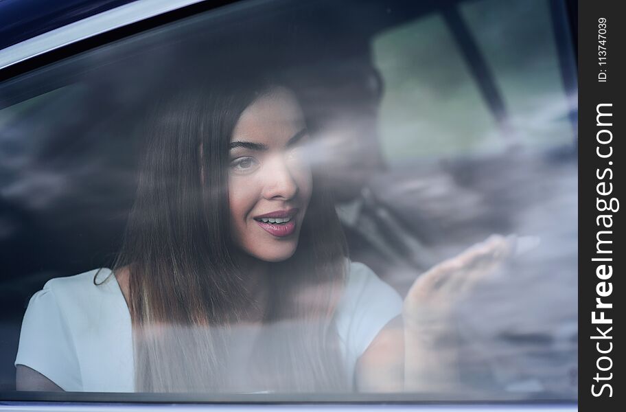 Young woman portrait in the car behind the window