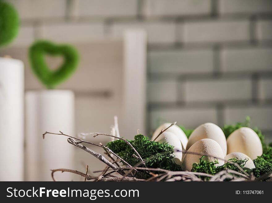 A bright Easter photo with a wreath, concrete vases, concrete eggs, moss. On a white brick wall background for your text