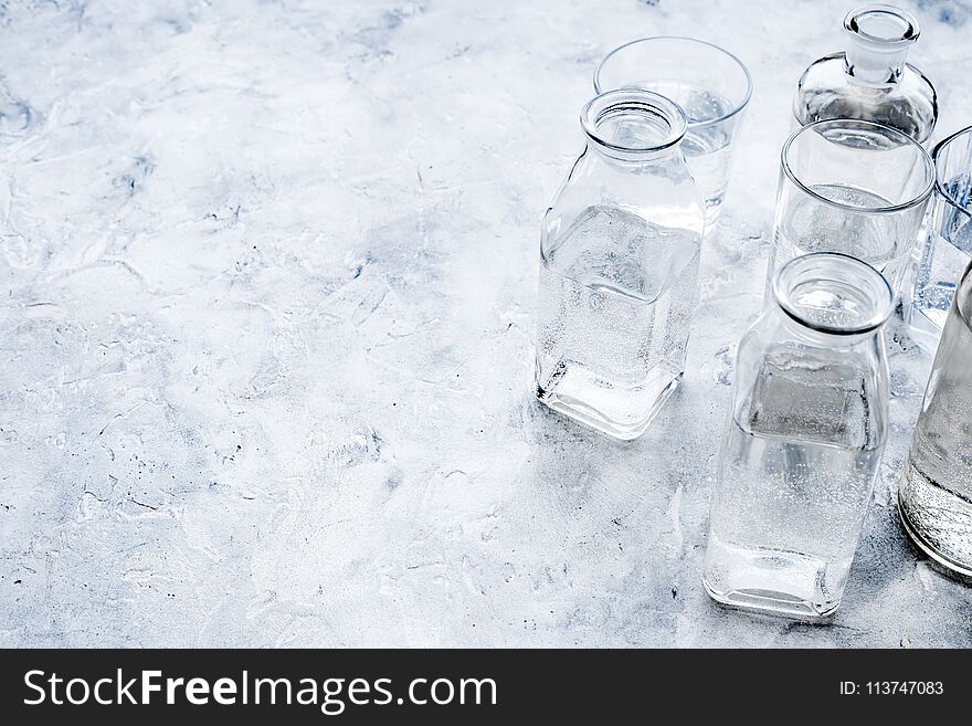 Drinks on the table. Pure water in jar and glasses on grey background space for text