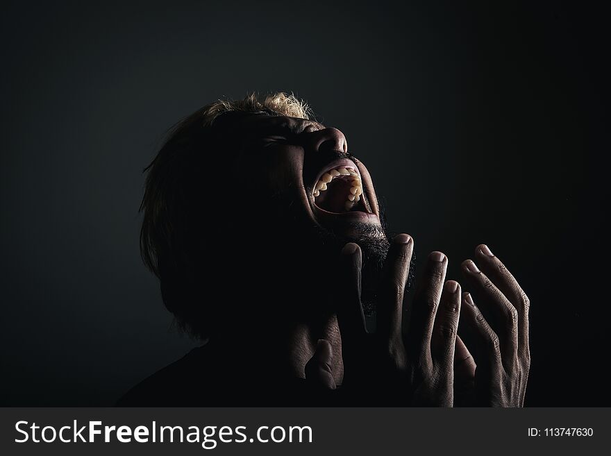 Handsome businessman shouting like crazy, Stressed with work. Studio portrait against black background.