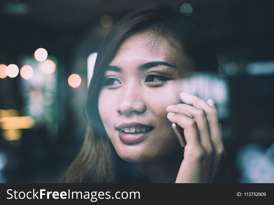 Young woman talking on mobile phone during rest in coffee shop background. Young woman talking on mobile phone during rest in coffee shop background