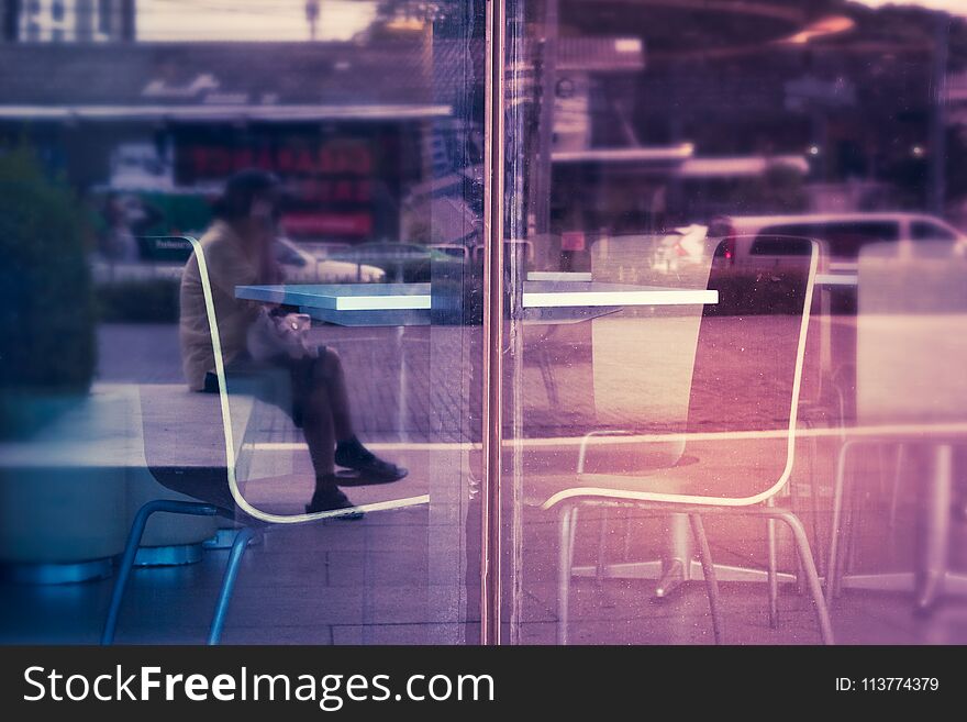 Empty table with chairs in a shop beside glass window.