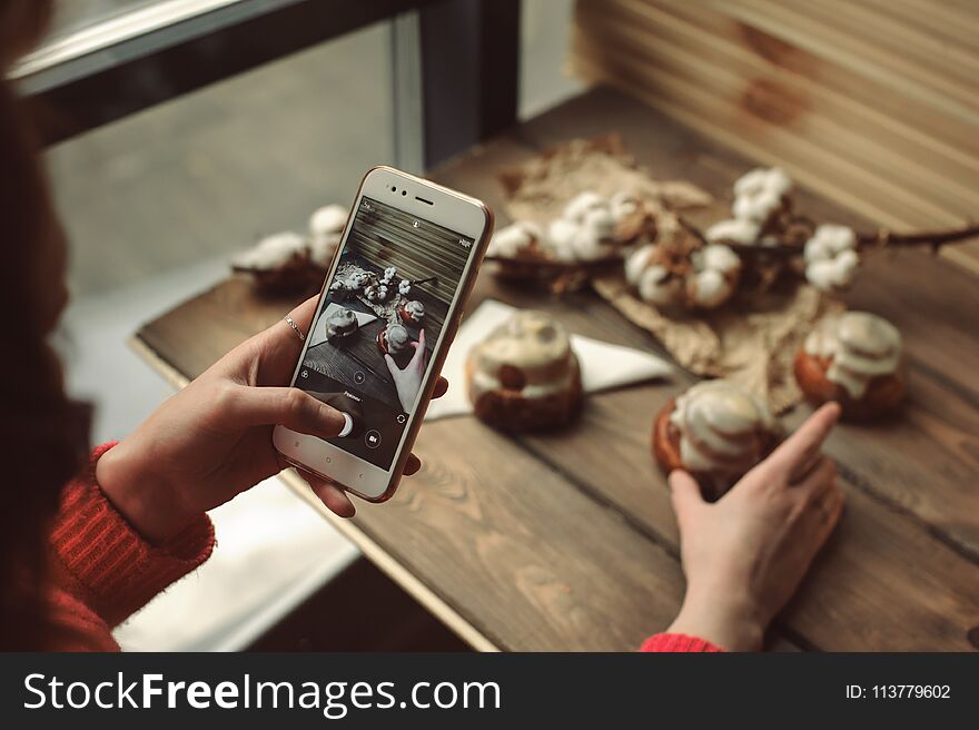 Female Make Mobile Photo With Cinnamon Rolls