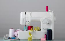 Household Electric Sewing Machine And Sewing Supplies, On Grey Stock Photo
