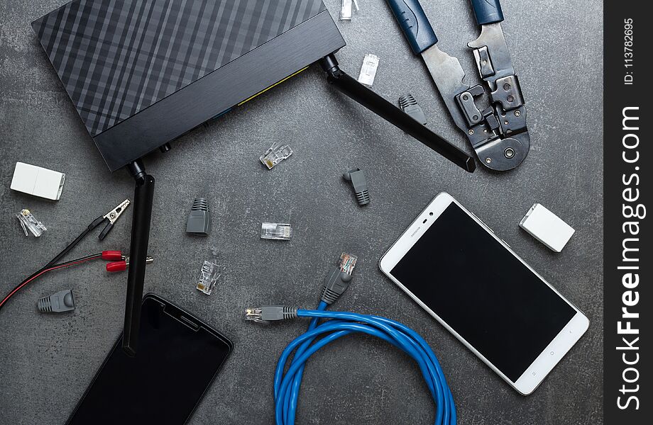 Smartphones And Router With The Necessary Parts And Tools To Connect, On Gray