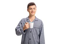 Teenage Boy Wearing Pajamas And Holding A Cup Royalty Free Stock Photo