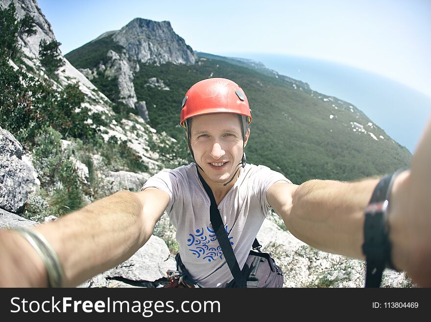 Man climber makes selfie photography with mountains and sea background. Man climber makes selfie photography with mountains and sea background