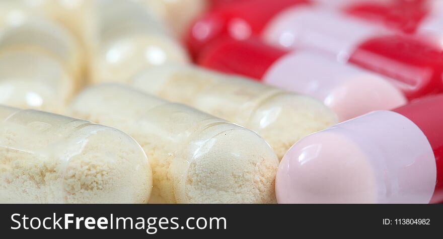 Close up of red and transparent probiotics and antibiotics capsules. Close up of red and transparent probiotics and antibiotics capsules